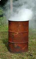 A rusted barrel with smoke pouring out the top